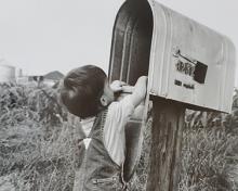 young boy getting the mail